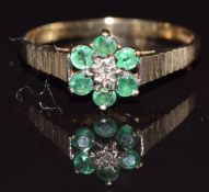 A 9ct gold ring set with a diamond and emeralds, size M, 1.3g