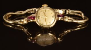 Omega 9ct gold ladies wristwatch with gold hands and hour markers, champagne dial, ruby set case and