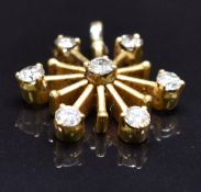A yellow metal pendant in the form of a stylised star set with seven round cut diamonds, total
