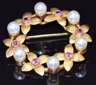 A 9ct gold brooch set with pearls and rubies in a floral setting, 4.7g