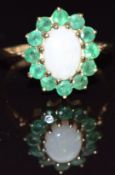 A 9ct gold ring set with an opal surrounded by emeralds, size K, 1.9g