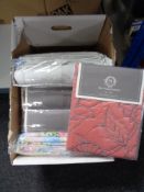 A box of new bedding including linen bed spread, quilt,