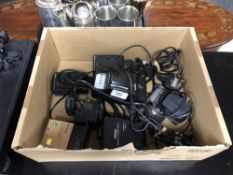 Four Nikon battery charging units, together with three Nikon camera batteries.