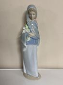 A Lladro figure of a girl holding flowers