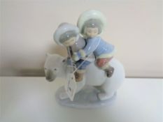 A Lladro figure, children on a polar bear.
