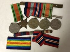 A group of three WWII medals on bar together with two further medals of the same war.