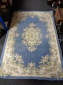 A floral woolen rug on blue ground,
