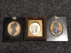 Two George III silhouette type miniatures together with a further portrait miniature behind glass.