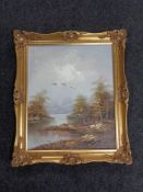A gilt framed oil on canvas - Ducks in flight over a pond