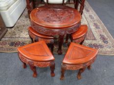 A carved Chinese occasional table fitted with nest beneath