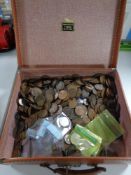 A vintage suitcase containing a large collection of coins,
