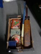 A box of vintage games, old Slazenger cricket bat, hockey stick,