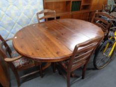 A circular pine ducal pedestal dining table and four chairs