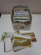 A box of early twentieth century and later colour and black and white postcards