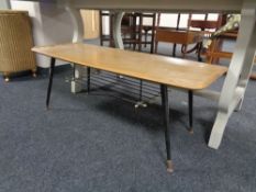 A mid 20th century low coffee table with metal under stretcher