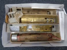 A box containing model railway, metal carriage and engine parts,