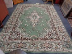 A machine made Persian designed carpet on green ground