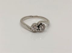 An antique white gold two stone diamond crossover ring,