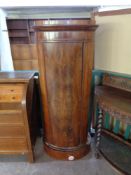 A 19th century oval mahogany single door cabinet
