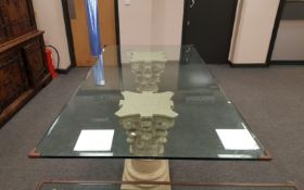 A contemporary glass topped twin pedestal dining table on Corinthian style columns,