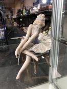 A Lladro figure of a ballerina seated on stool