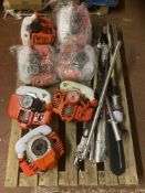A pallet of seven garden multi tool engines and attachments