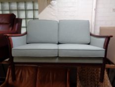 A 20th century stained beech framed two seater settee upholstered in a green fabric with similar