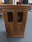 An eastern hardwood double door cabinet fitted two drawers beneath