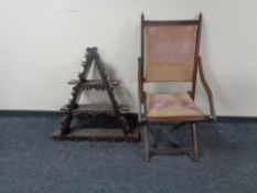 A early 20th century folding beech framed and canvas armchair and a triangular wall mounted shelf