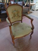 A beech framed French style salon armchair upholstered in a tapestry fabric