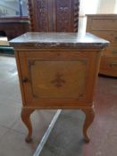 A 20th century pine marble topped bedside cabinet