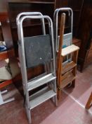 A set of folding pine library steps together with three sets of folding aluminum steps