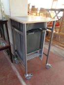 A portable office table containing twelve folding metal chairs beneath