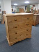 A contemporary pine five drawer chest