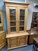 An early 20th century oak double door bookcase with cupboard beneath, height 207 cm, width 106 cm,