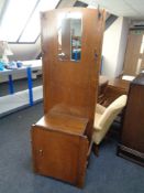 An oak mirrored hall stand fitted a cupboard