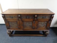 An Edwardian oak triple door sideboard on bulbous legs, height 94 cm, width 149 cm, depth 53 cm.