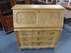 A 20th century blond oak writing bureau, height 106 cm, width 98 cm, depth 42 cm.