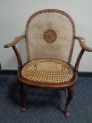 An Edwardian beech framed bergere armchair