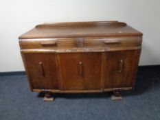 An Edwardian carved oak triple door sideboard, height 95 cm, width 137 cm, depth 58 cm.