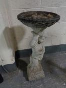 A composite cherub bird bath
