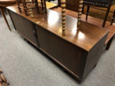 A mid 20th century low sideboard with shutter doors