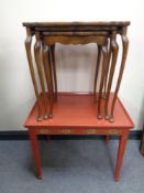 A nest of three walnut pie crust edge tables together with a further painted table with brass
