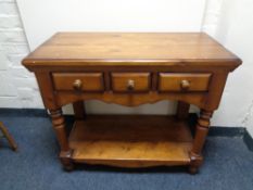 A contemporary pine hall table with three drawers
