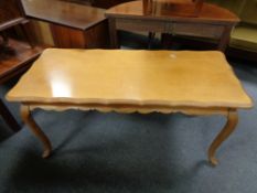 A continental shaped oak coffee table on cabriole legs