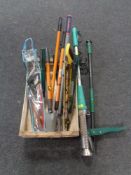 A crate containing garden tools, loppers, hand saws,