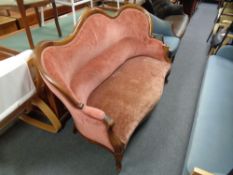 A late 19th century shaped mahogany framed settee upholstered in a pink dralon fabric