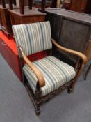 A 20th century oak armchair upholstered in a striped covering