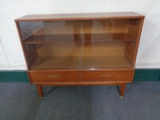 A twentieth century teak sliding glass door bookcase