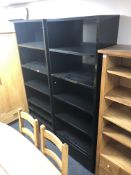 A pair of contemporary black high gloss open bookshelves
